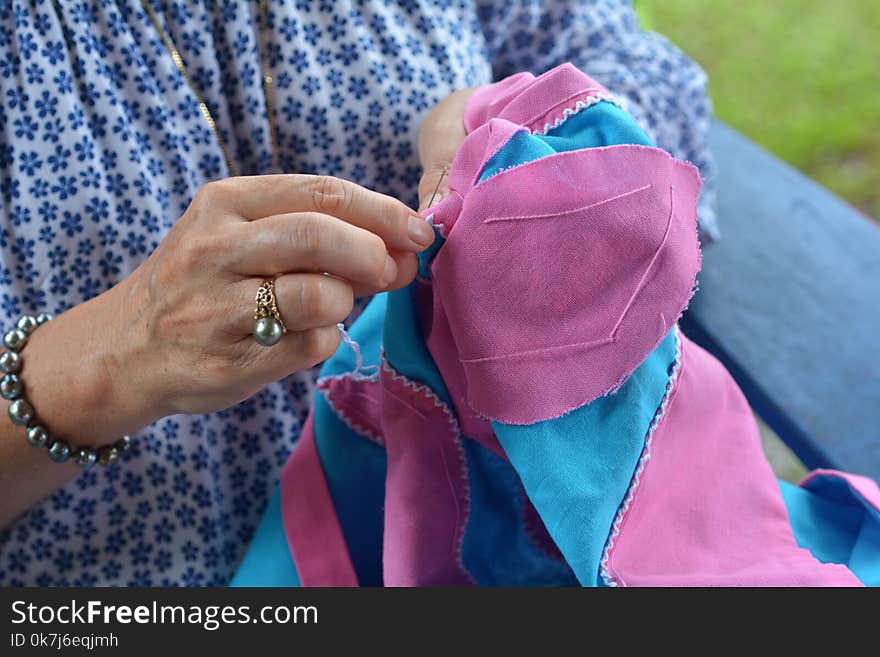 Hands of a mature Polynesian Cook Islander woman sewing a tivaevae in Rarotonga Cook Islands