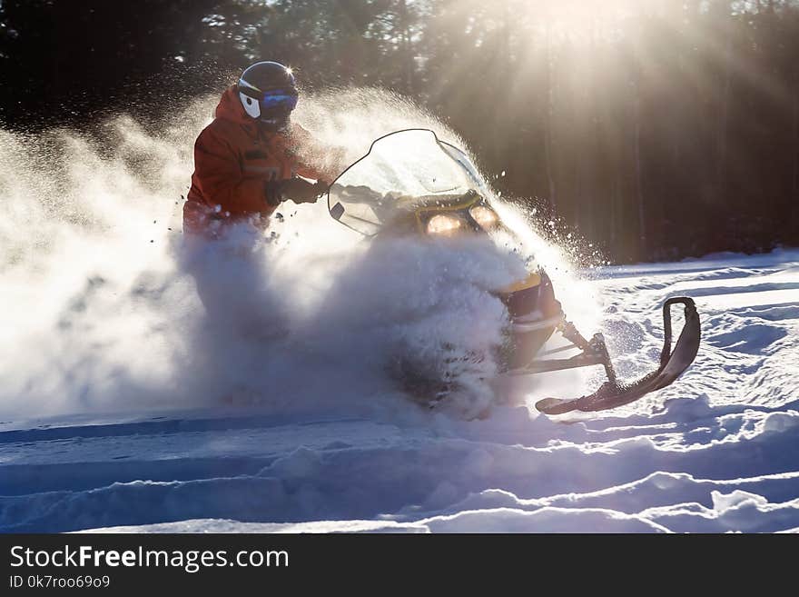 Athlete on a snowmobile moving in the winter forest in the mountains of the Southern Urals.