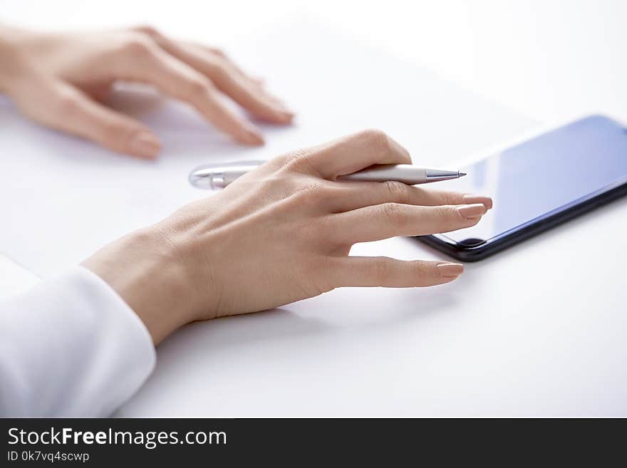 Close-up shot of businesswoman`s hand using mobile phone and text messaging.