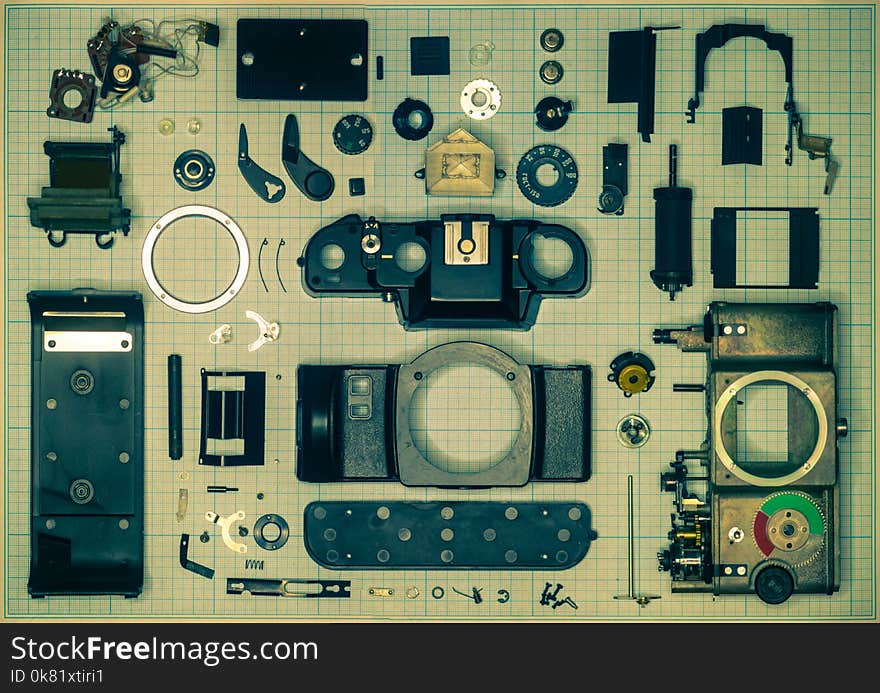 parts are completely disassembled old retro film SLR camera on graph paper, close-up, toned. parts are completely disassembled old retro film SLR camera on graph paper, close-up, toned