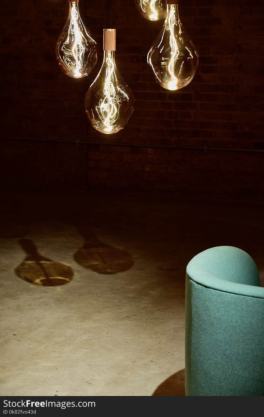 Four Hanging Light Bulbs Beside Chair