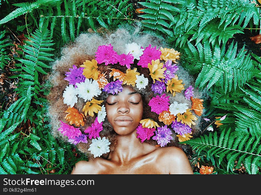 Woman With Floral Headdress Lying on Green Leaf Plants