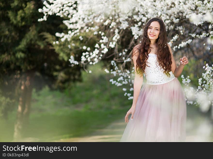 Young long-haired woman in the garden blooming in spring. Young long-haired woman in the garden blooming in spring