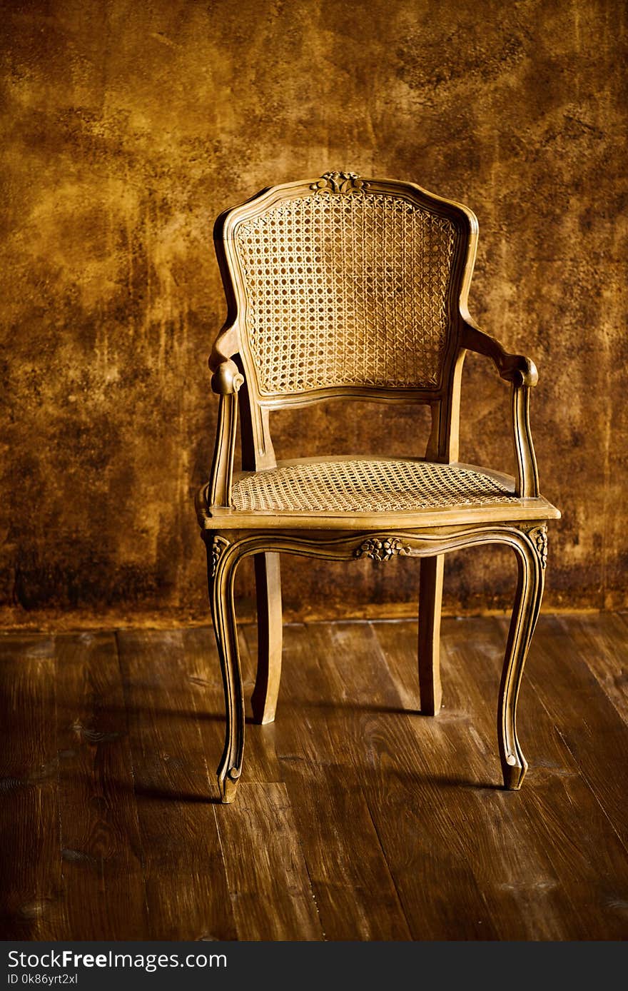 Old Chair On A Brown Wall Background.