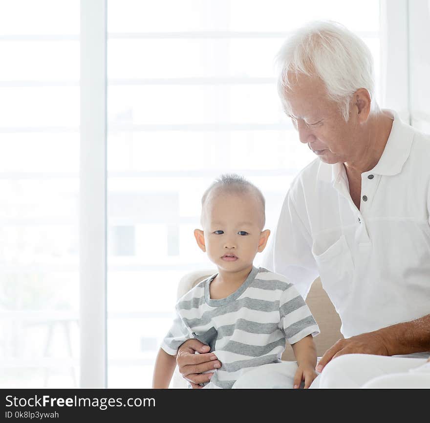 Portrait of Asian grandfather and grandchild at home, family indoor lifestyle. Portrait of Asian grandfather and grandchild at home, family indoor lifestyle.