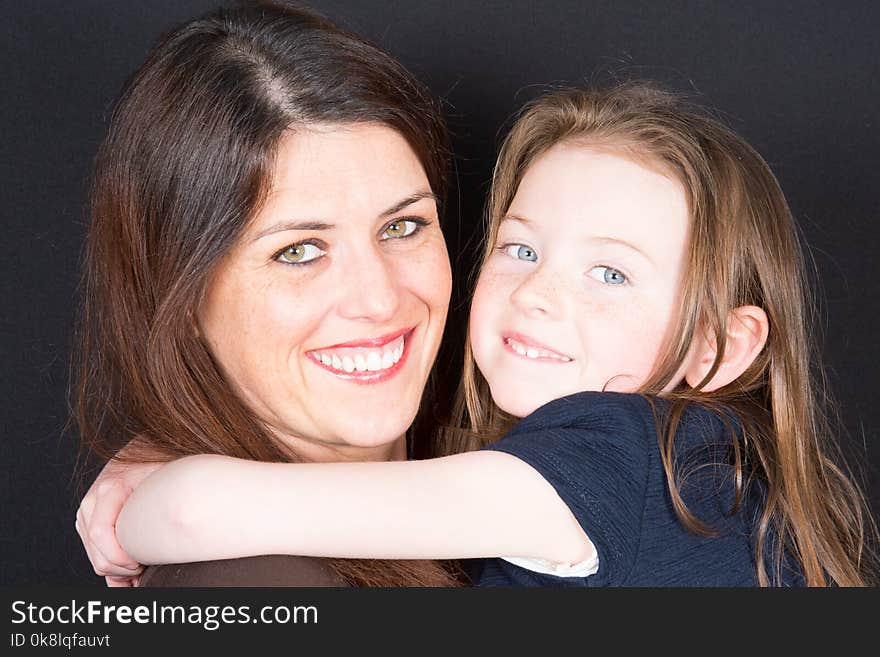 Smiling mother and daughter embracing