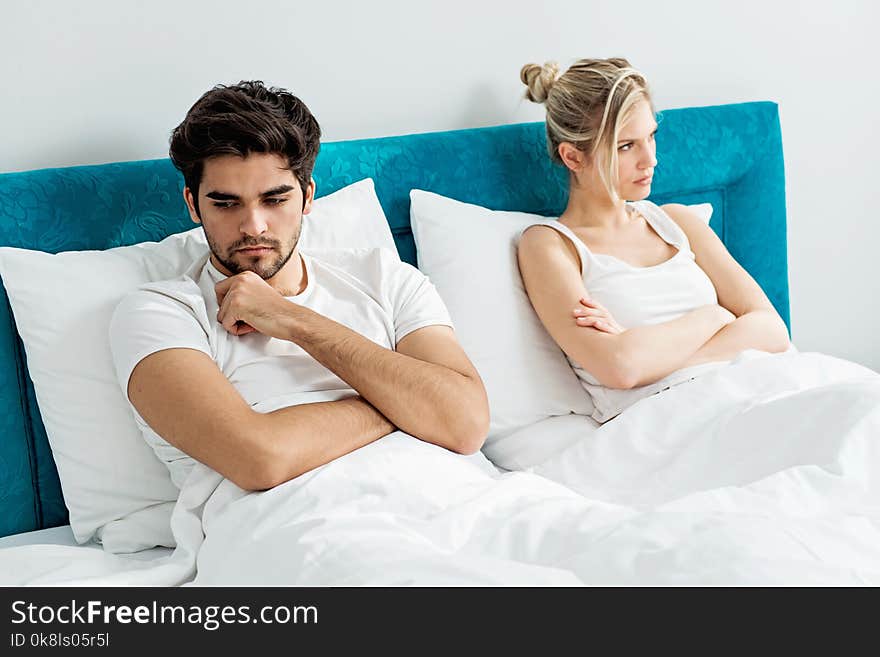 Young couple on the bed; problems in the bedroom