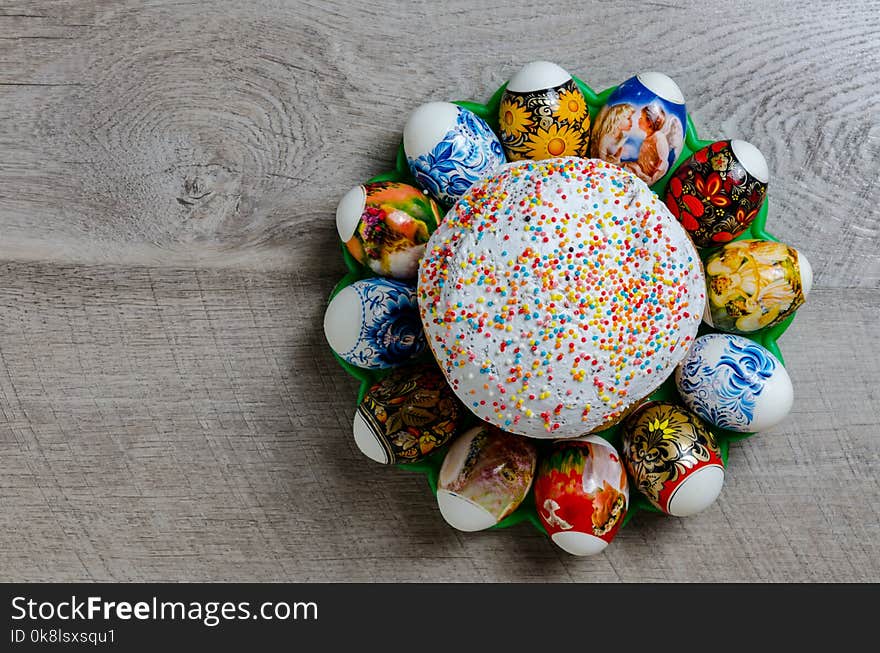 Easter bread with white icing and eggs lined in a circle on a wooden background. Easter bread with white icing and eggs lined in a circle on a wooden background.