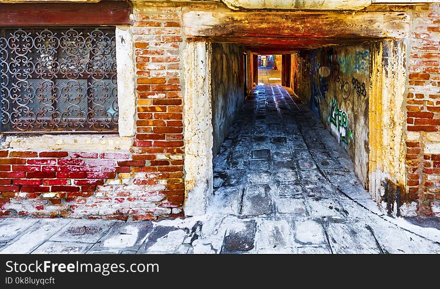 Narrow passage between old houses in Venice. Street with archway in the medieval italian town. Narrow passage between old houses in Venice. Street with archway in the medieval italian town.