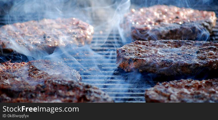 Hamburgers on the grill outdoors at a picnic. Hamburgers on the grill outdoors at a picnic.