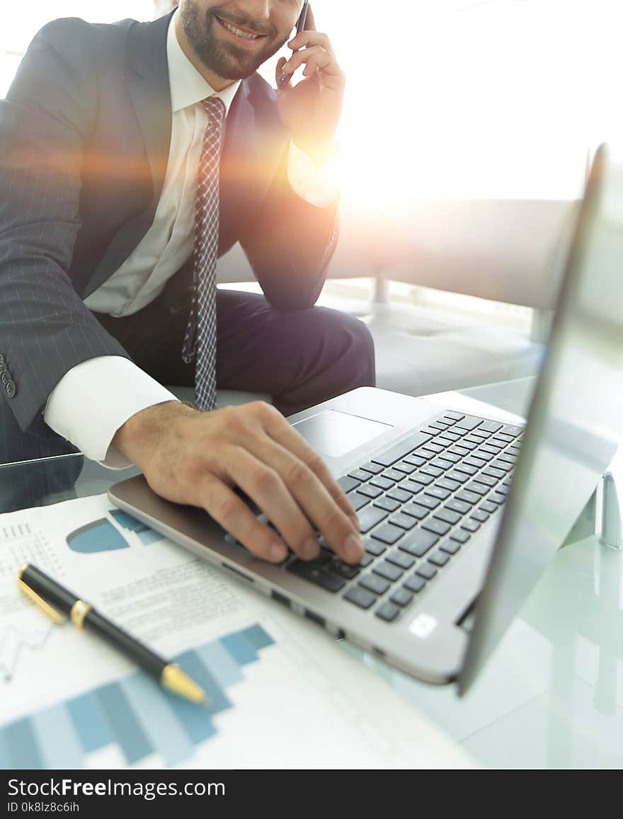 Foreground businessman talking on a smartphone