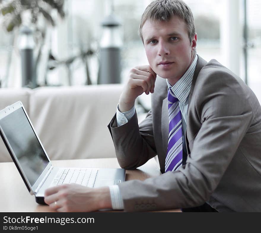 Portrait of young man sitting at his desk in the office. Portrait of young man sitting at his desk in the office