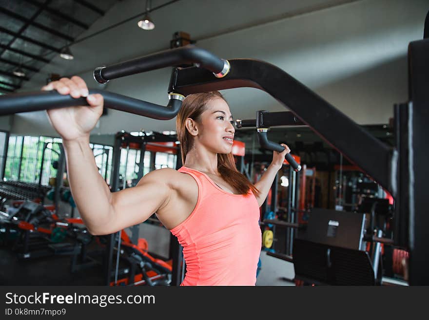 Close up young adult fitness woman doing pull ups