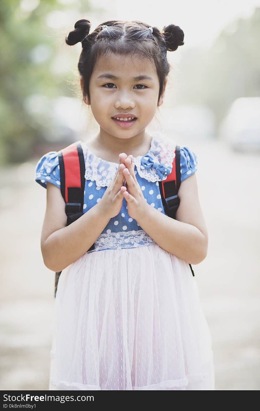 Thai children posting sawasdee acting toothy smiling face outdoor