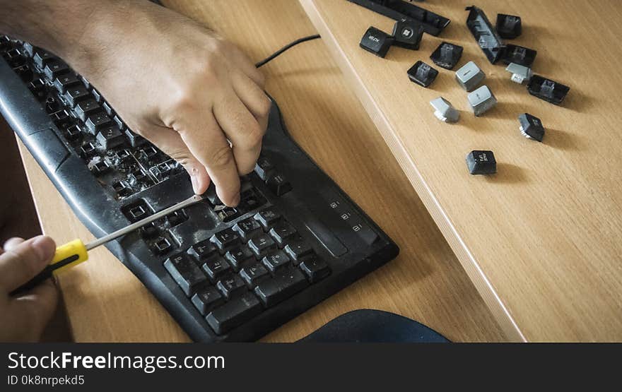 Close-up of male hands cleaning a dirty keyboard. Close-up of male hands cleaning a dirty keyboard