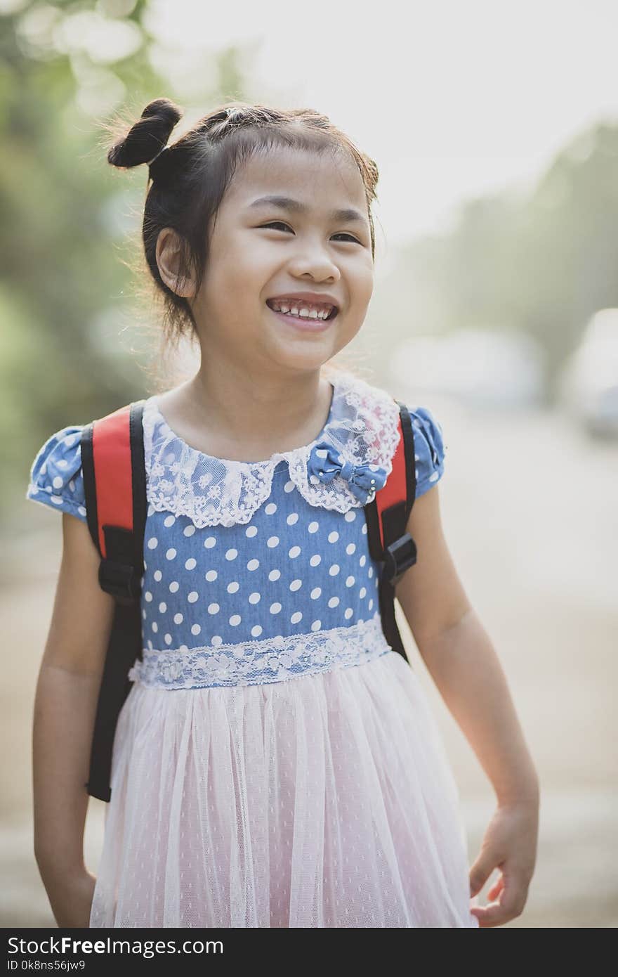 Cheerful asian children school pack on back toothy smiling face