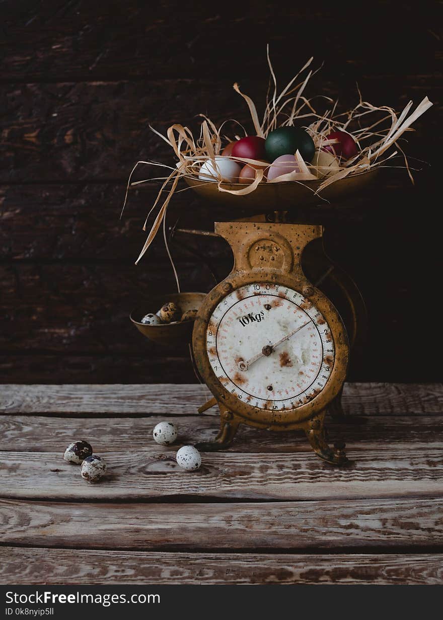 Quail eggs by scales with painted chicken eggs on table