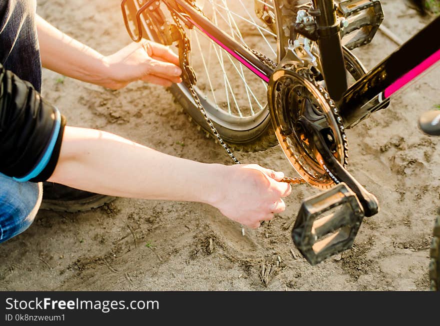 The guy repairs the bicycle. chain repair. cyclist. unratitude on the road, travel, close-up.