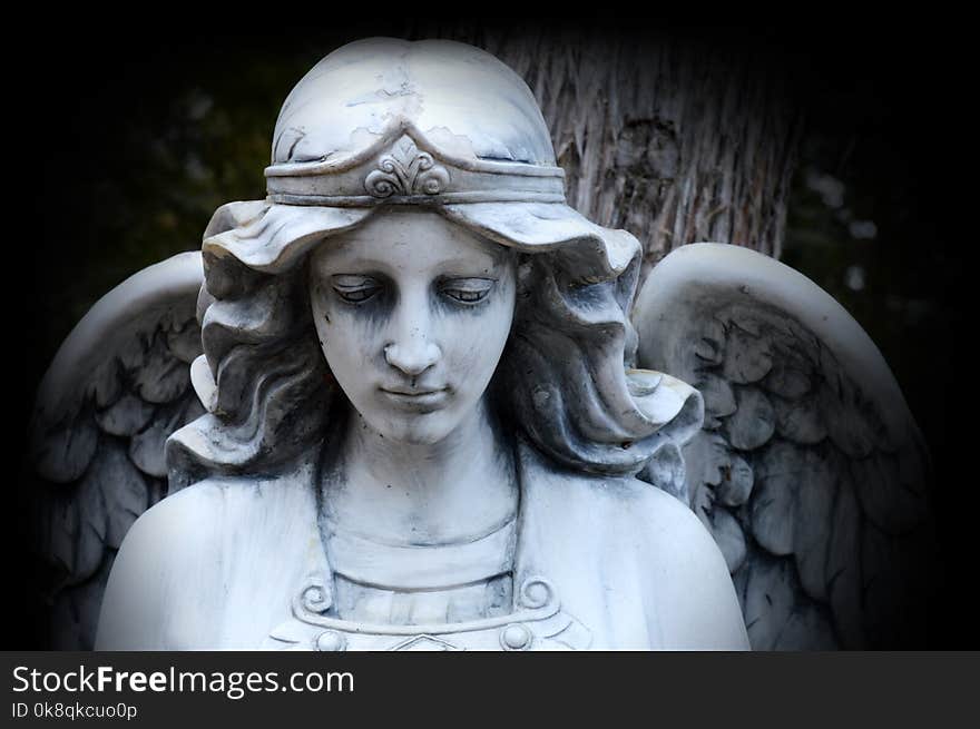 A beautiful Angel watching over God`s creation set in a stone statue. A beautiful Angel watching over God`s creation set in a stone statue.