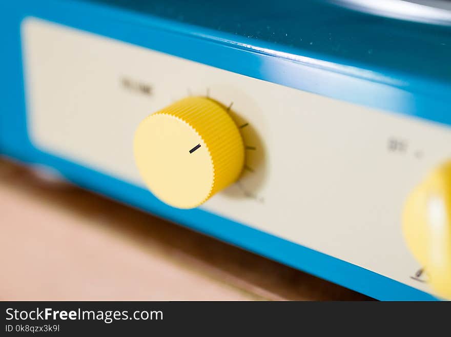 Yellow volume button of blue portable turntables and record players. Yellow volume button of blue portable turntables and record players
