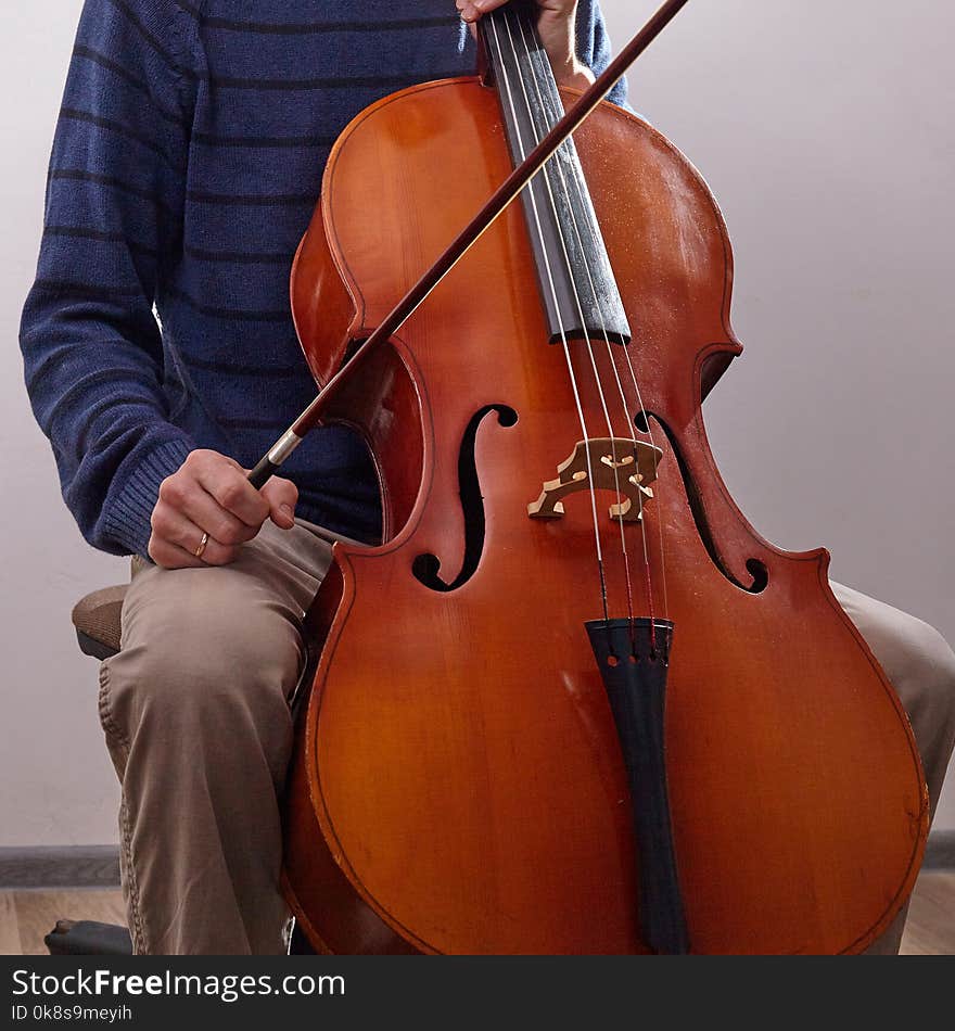 Man With Cello In Room With Wall