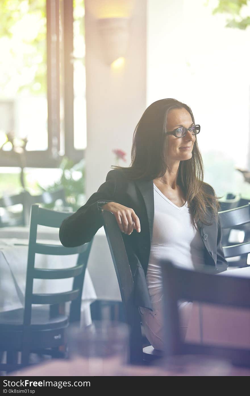 Thoughtful and pretty young woman sitting in a restaurant