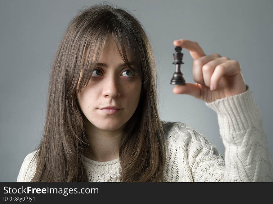 Young Woman Holding a King Chess Piece with Her Hand. Young Woman Holding a King Chess Piece with Her Hand