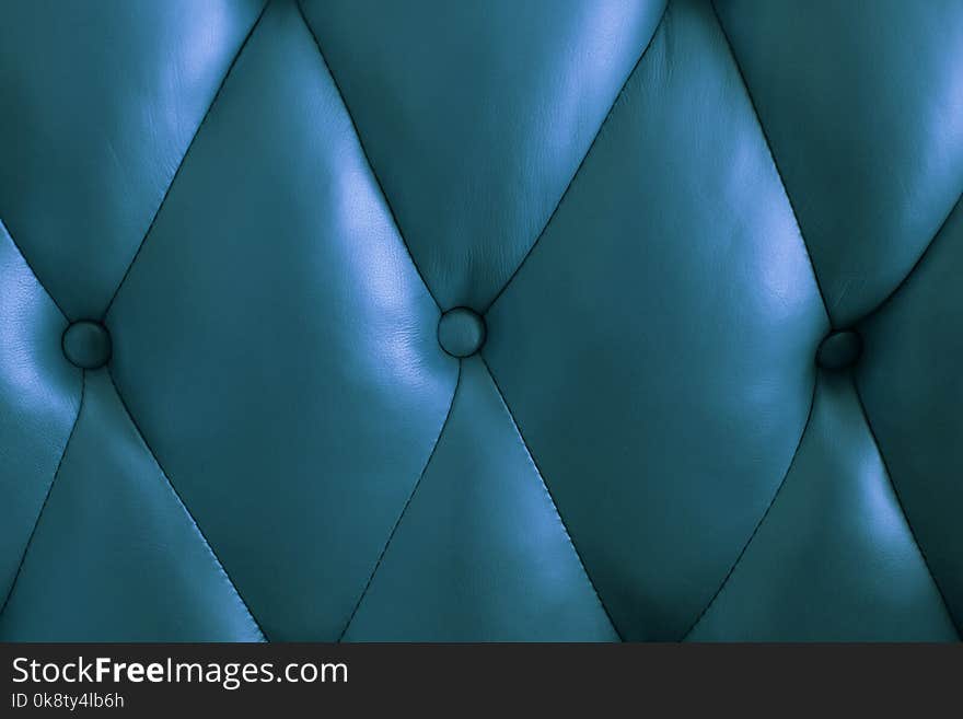 The blue surface of the leather back of the vintage couch. The blue surface of the leather back of the vintage couch.