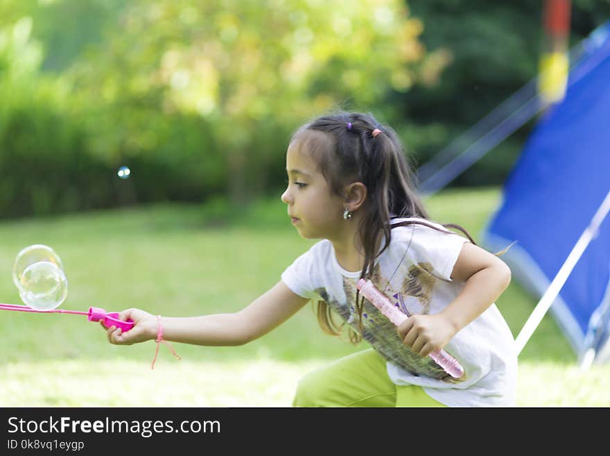 Happy and Beautiful Girl Playing with Soap Bubbles Outdoors. Happy and Beautiful Girl Playing with Soap Bubbles Outdoors