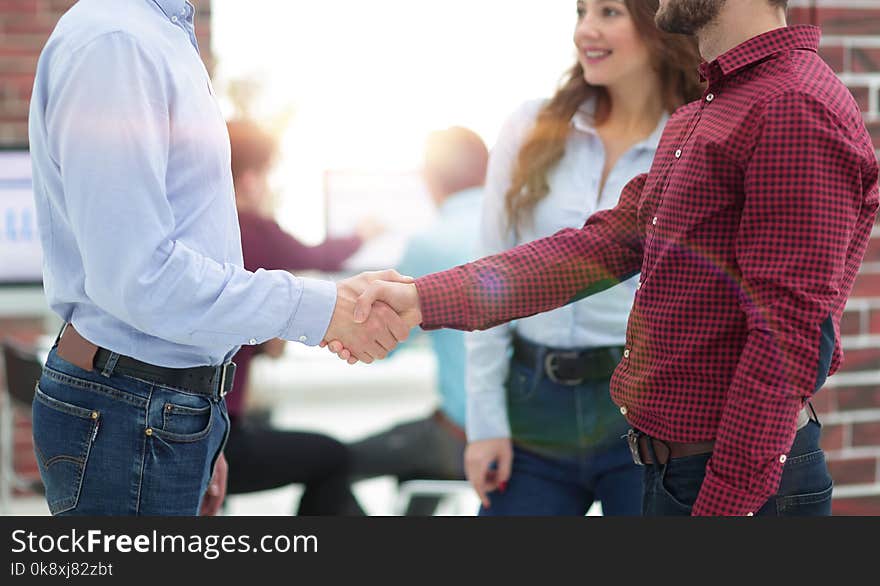 Handshake between businesspeople in a modern office. Handshake between businesspeople in a modern office.