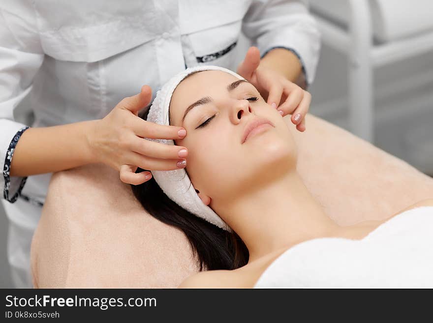 Beautician Doing Face Massage To Beautiful Brunette.