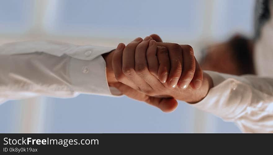 Closeup of a business handshake, on bright background. Closeup of a business handshake, on bright background