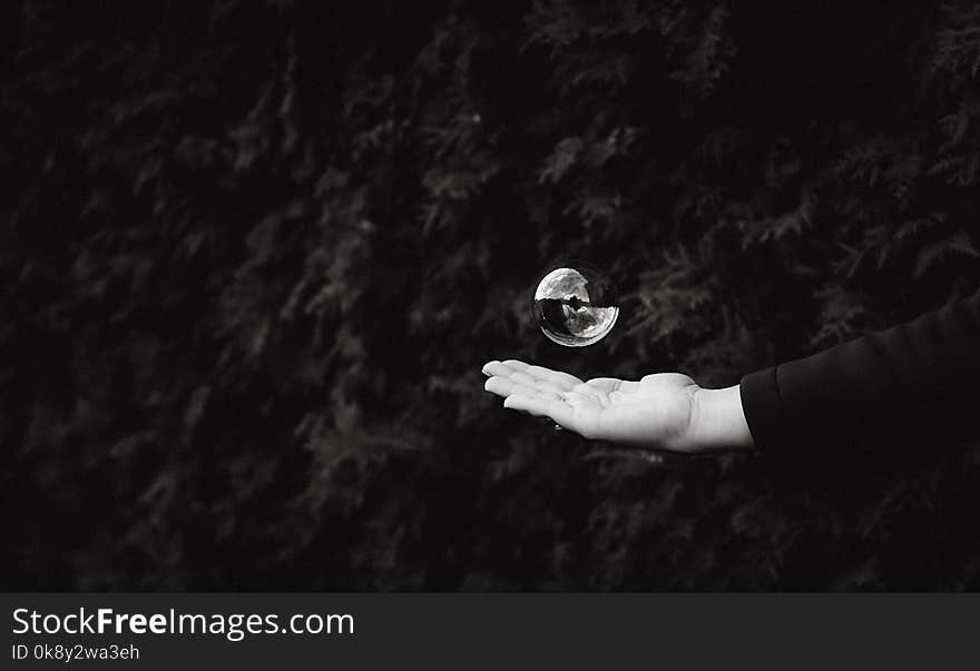 Soap bubble on a dark background with the palm of a child. Soap bubble on a dark background with the palm of a child