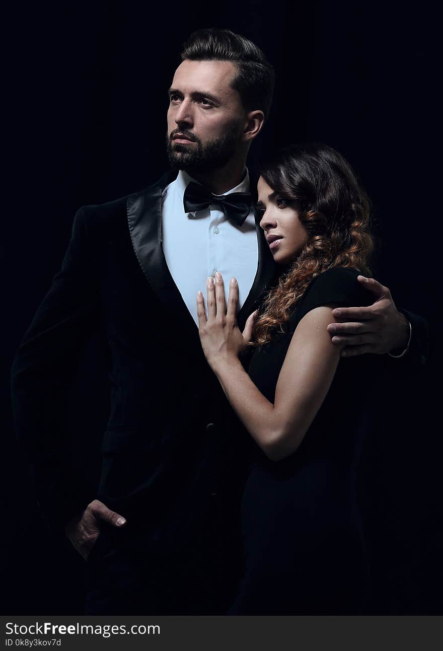 Portrait of young couple in love posing at studio dressed in classic clothes. Portrait of young couple in love posing at studio dressed in classic clothes