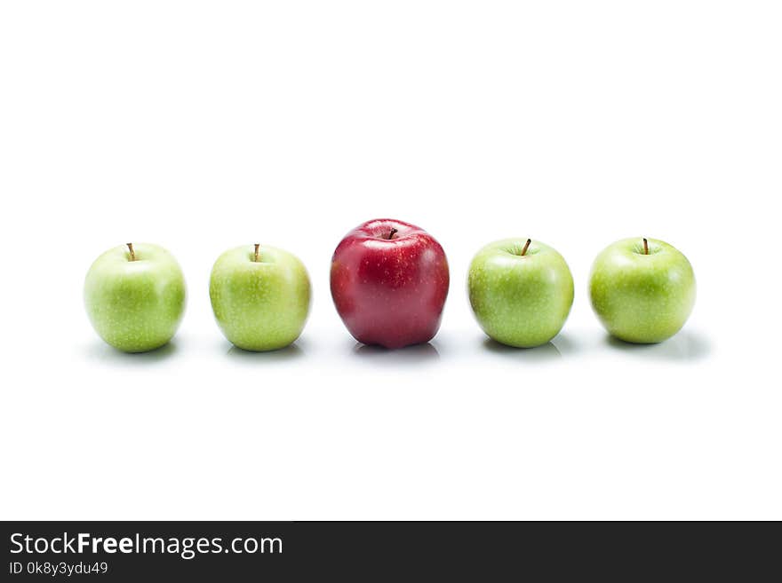 One bite red apple among green apples on white background to be not like others. One bite red apple among green apples on white background to be not like others