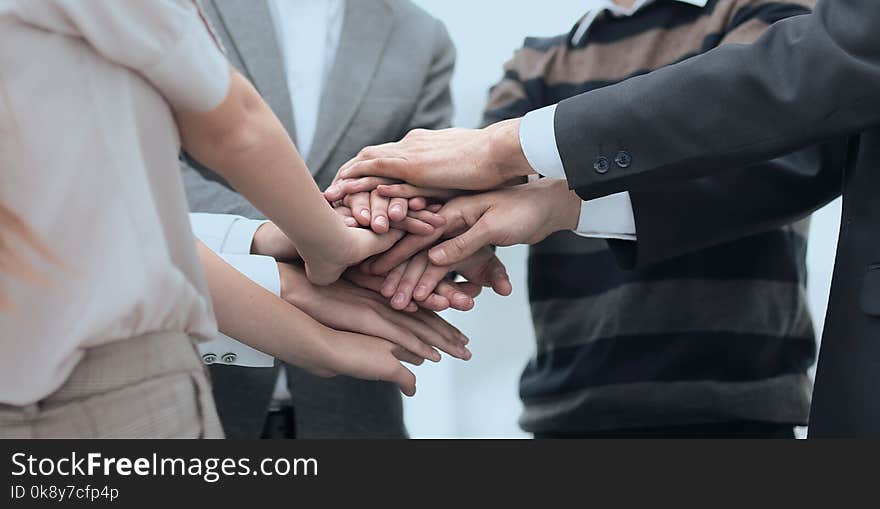 Teamwork concept.Business team standing joining hands together in the office.