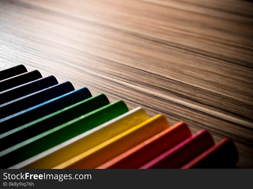 Colorful rainbow pencils on the brown table backgrounds