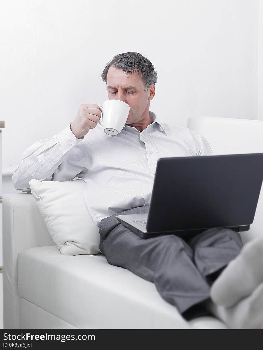 Businessman Drinking Tea And Working On Laptop In The Hotel Room