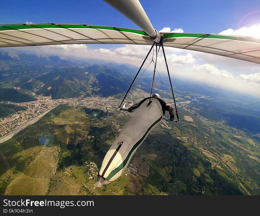 Hang glider pilot flies high over alpine terrain during hanggliding competition in Provance, France.