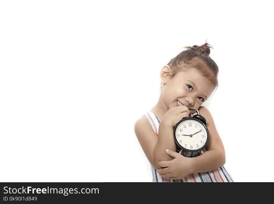 asian baby kid girl playing black alarm clock on gray background. asian baby kid girl playing black alarm clock on gray background