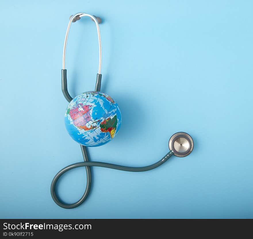 World health day ,Stethoscope wrapped around globe on pastel blue background. Save the wold, Global health care and Green Earth day concept. World health day ,Stethoscope wrapped around globe on pastel blue background. Save the wold, Global health care and Green Earth day concept