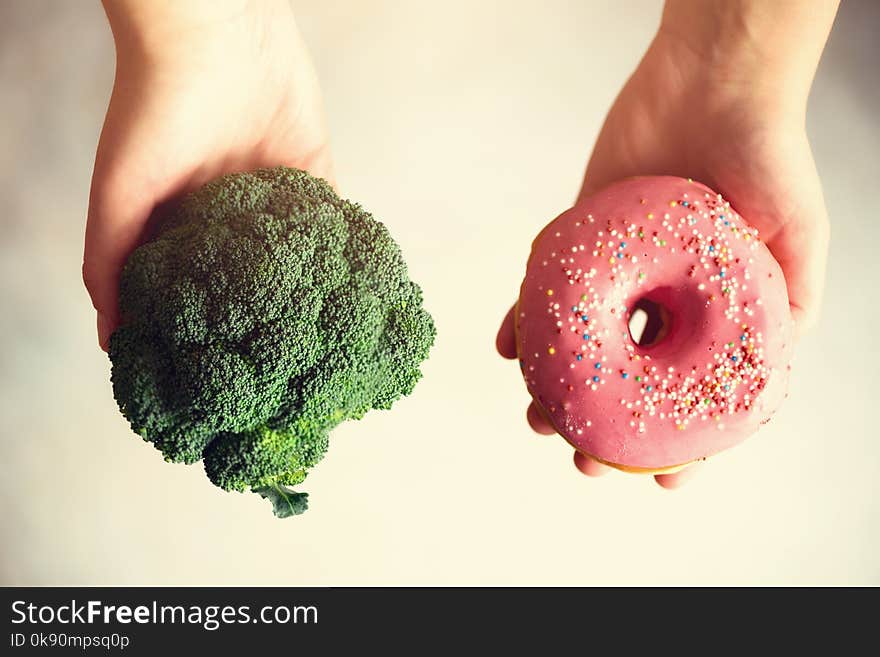 Young Woman In White T-shirt Choosing Between Broccoli Or Junk Food, Donut. Healthy Clean Detox Eating Concept