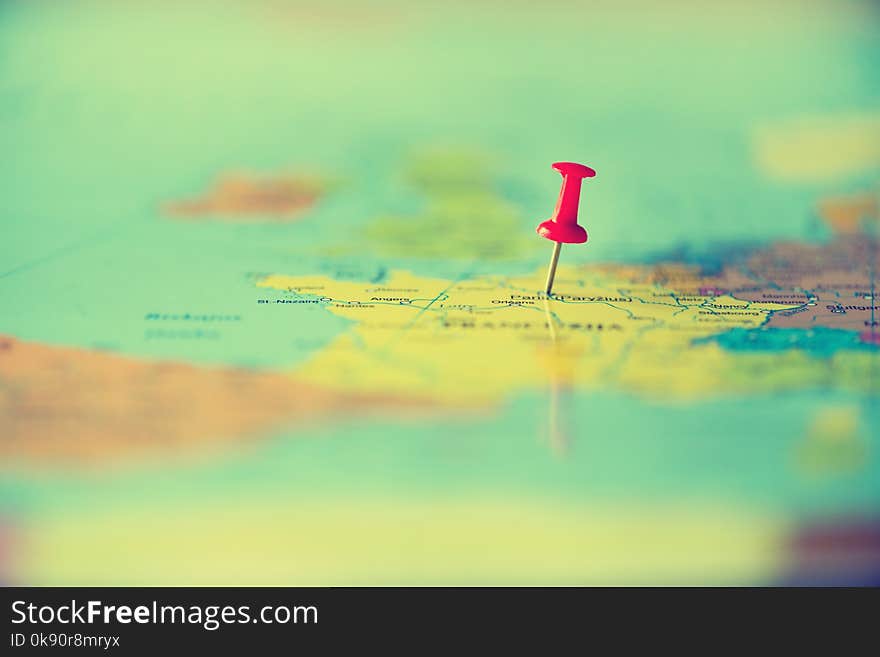 Red pushpin, thumbtack, pin showing the location, travel destination point on map. Copy space, lifestyle concept.