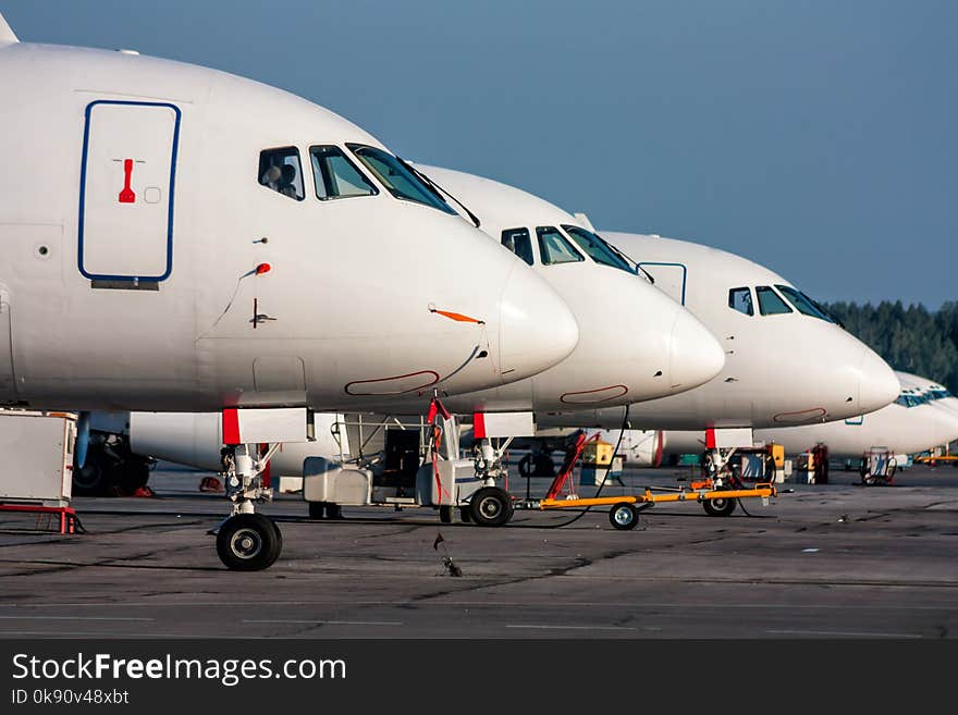 Close-up passenger airplane noses in line at the parking lot of airport