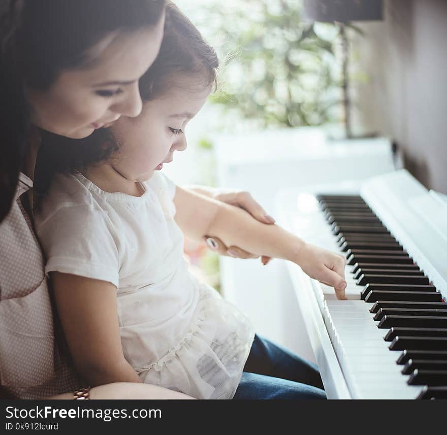 Mom teaching her little daughter piano playing. Mom teaching her little daughter piano playing