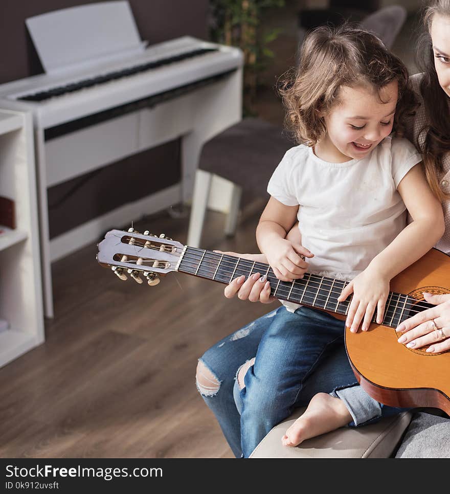 Mother and daughter playing a classic guitar. Mother and daughter playing a classic guitar