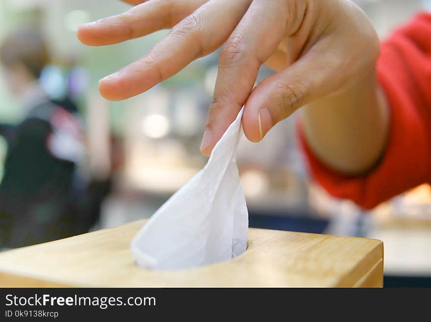 Women hand picking napkin/tissue paper from the tissue box