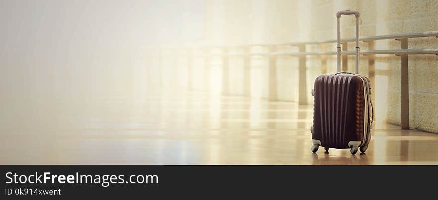 Packed travel suitcase, airport. Summer holiday and vacation concept. Traveler baggage, brown luggage in empty hall interior. Copy space. Banner.