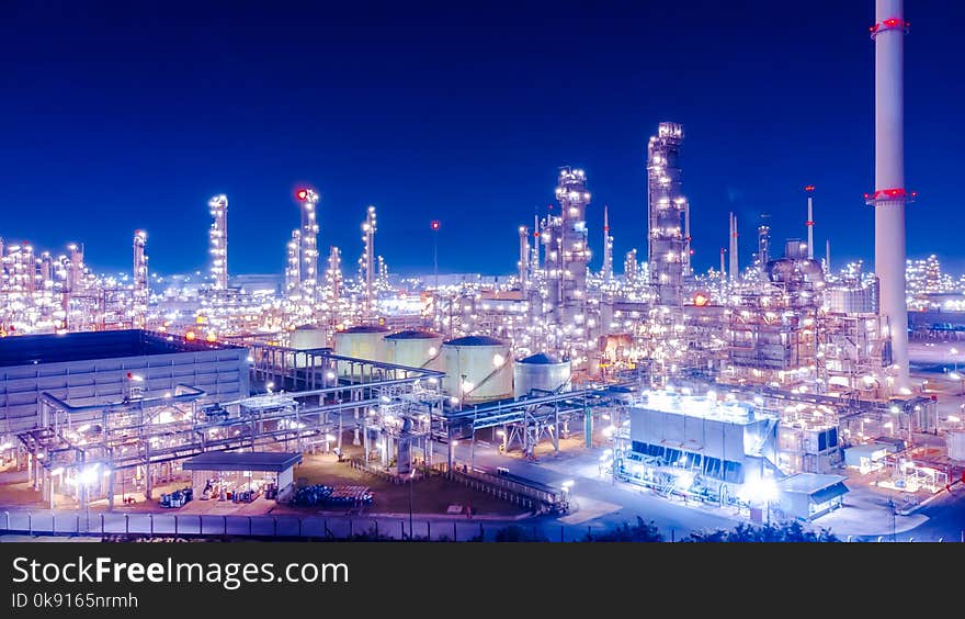 Oil storage tank with oil refinery background, Oil refinery plant at blue night sky.