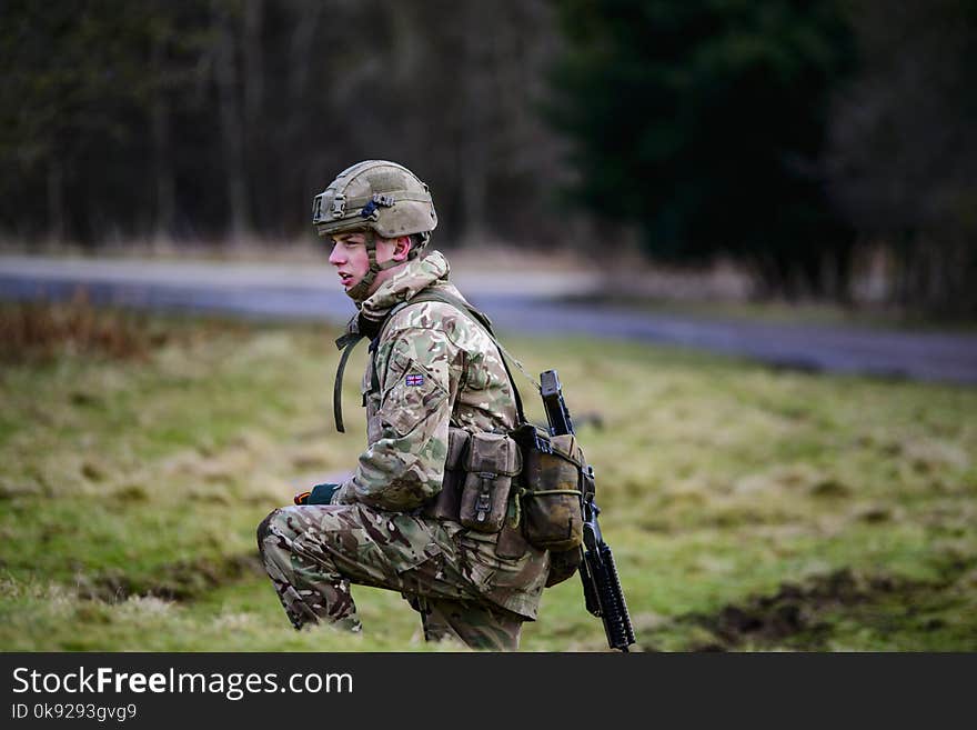 Soldier in Green and Brown Camouflage Uniform on Grass Field